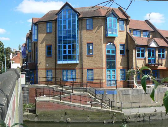 View along bridge parapet showing canal and the late 1980s Canal Court building on road and canalside corner