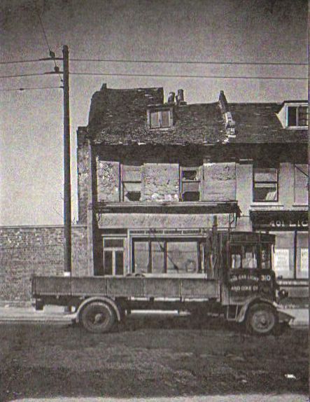 dilapidated house of two storeys with a less dilapidated building to the right