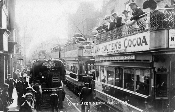 Four open top trams, nose to tail