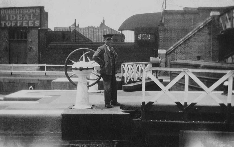 Black & white photo showing a uniformed man at Brentford Lock